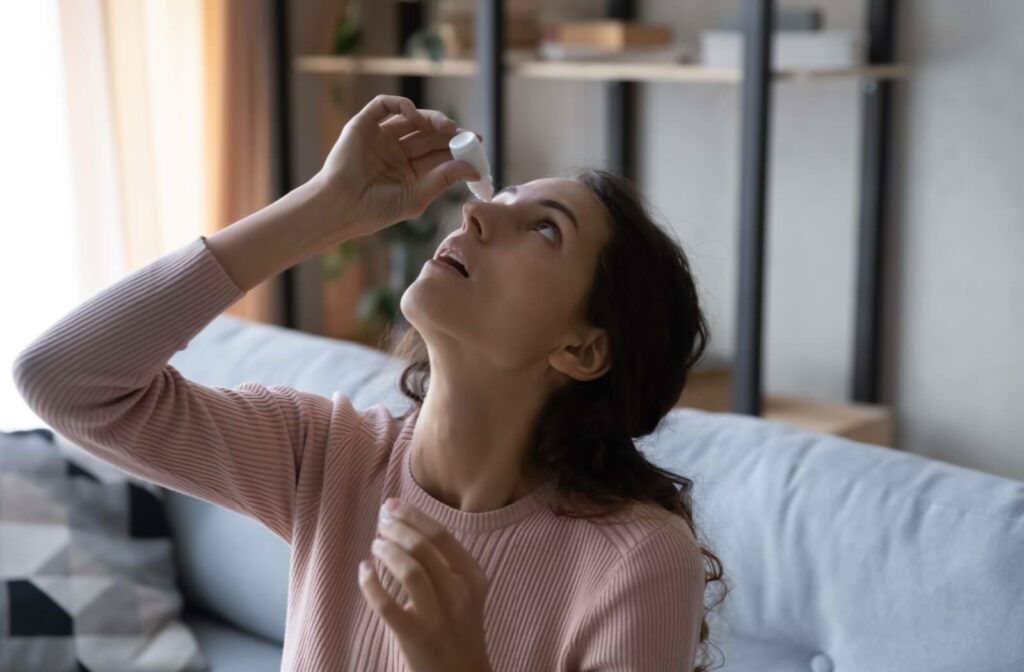 Woman puts eye drops in her eyes to try and treat meibomian gland dysfunction