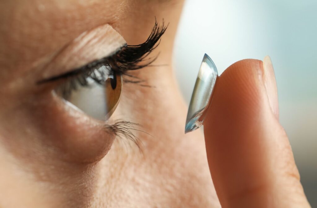 A closeup of someone putting in a contact lens to help with the symptoms of their dry eye.