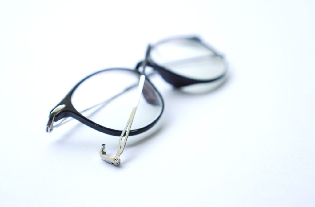 Close up of a broken pair of glasses on a white table